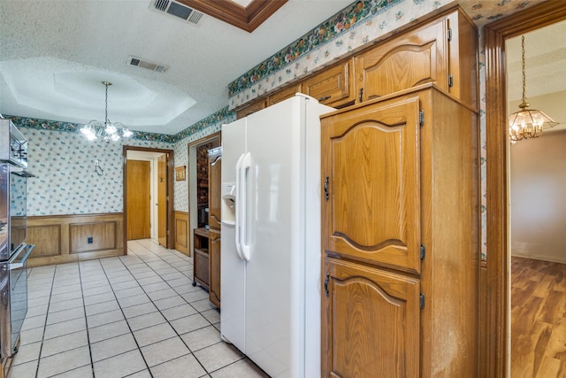 3506 Carla Dr, Rowlett, TX 75088 - kitchen with a chandelier, white fridge with ice dispenser, wallpapered walls, a textured ceiling, and wainscoting