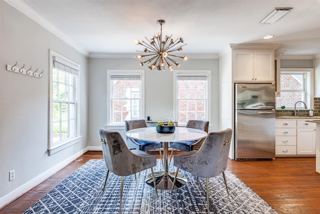 6802 Hammond Ave, Dallas, TX 75223 - dining space with a chandelier, ornamental molding, baseboards, and dark wood finished floors
