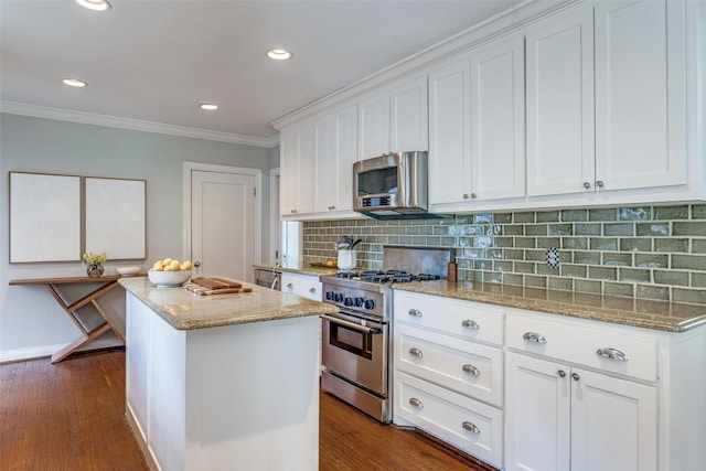 6802 Hammond Ave, Dallas, TX 75223 - kitchen featuring stainless steel appliances, a kitchen island, ornamental molding, white cabinets, and dark wood finished floors