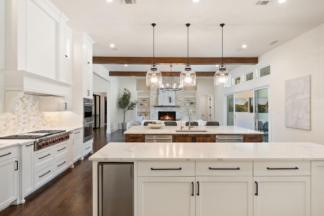 2012 Honey Ln, Celina, TX 75009 - kitchen featuring a sink, appliances with stainless steel finishes, a center island, dark wood finished floors, and backsplash