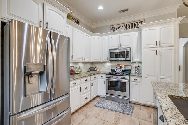 725 Bluebird St, Fort Worth, TX 76140 - kitchen featuring appliances with stainless steel finishes, crown molding, tasteful backsplash, white cabinets, and light stone countertops