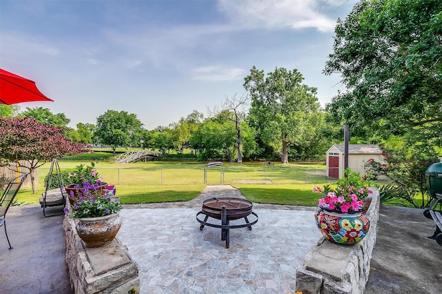 725 Bluebird St, Fort Worth, TX 76140 - view of patio / terrace with an outdoor fire pit, a storage unit, an outbuilding, and view of wooded area