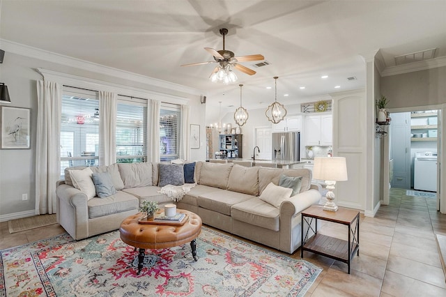 725 Bluebird St, Fort Worth, TX 76140 - living room featuring washer / dryer, a ceiling fan, ornamental molding, a chandelier, and light tile patterned flooring