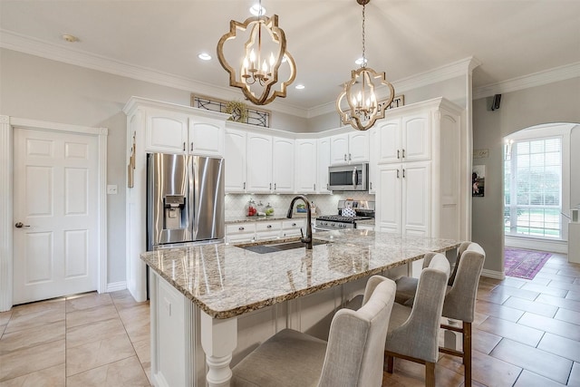725 Bluebird St, Fort Worth, TX 76140 - kitchen with appliances with stainless steel finishes, a sink, a chandelier, arched walkways, and light tile patterned floors
