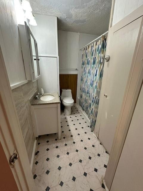 301 Dogwood Ave, Princeton, TX 75407 - bathroom featuring vanity, toilet, tile patterned floors, a shower with curtain, and a textured ceiling