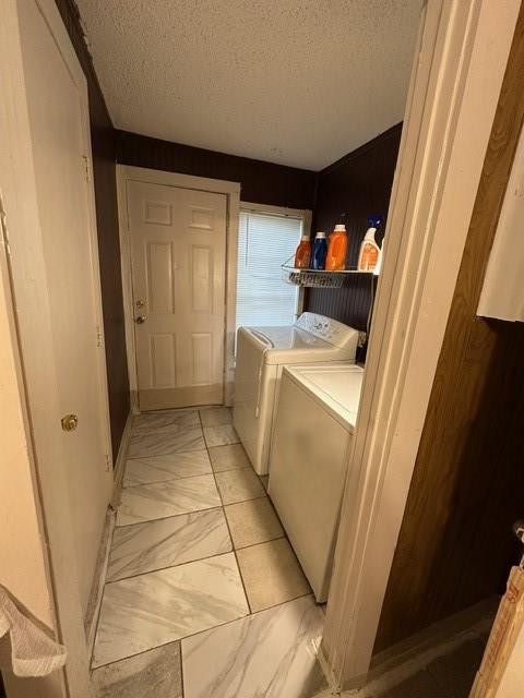 301 Dogwood Ave, Princeton, TX 75407 - washroom with washing machine and clothes dryer, a textured ceiling, and light marble finish flooring