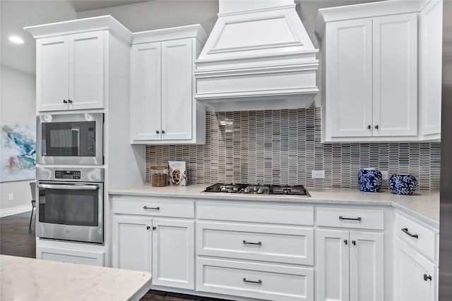 1128 Lake Hills Trl, Roanoke, TX 76262 - kitchen with stainless steel appliances, custom range hood, white cabinetry, and recessed lighting