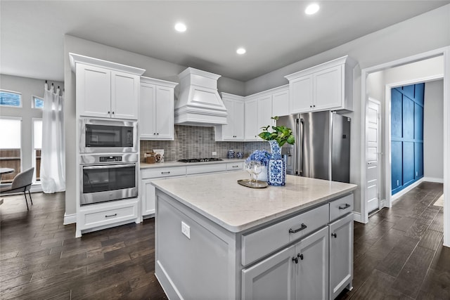 1128 Lake Hills Trl, Roanoke, TX 76262 - kitchen with stainless steel appliances, premium range hood, white cabinetry, dark wood-style flooring, and recessed lighting