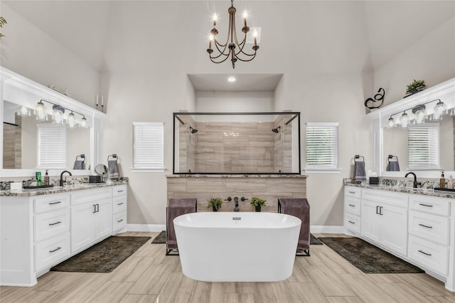 221 Greene Rd, Weatherford, TX 76087 - full bathroom featuring a chandelier, high vaulted ceiling, a shower stall, two vanities, and a freestanding tub