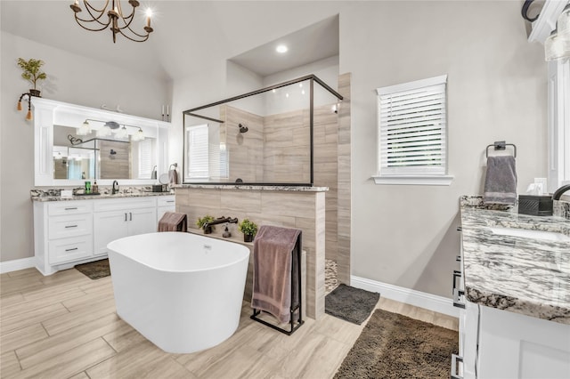 221 Greene Rd, Weatherford, TX 76087 - bathroom featuring a tile shower, a chandelier, vanity, a freestanding tub, and baseboards