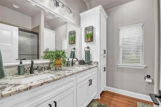 221 Greene Rd, Weatherford, TX 76087 - full bathroom featuring baseboards, double vanity, wood finished floors, and a stall shower