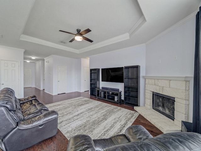 905 Jonius Creek Dr, Little Elm, TX 75068 - living area featuring a raised ceiling, ceiling fan, a stone fireplace, crown molding, and wood finished floors