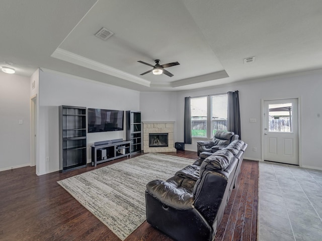905 Jonius Creek Dr, Little Elm, TX 75068 - living room featuring a tray ceiling, a ceiling fan, a fireplace, baseboards, and crown molding