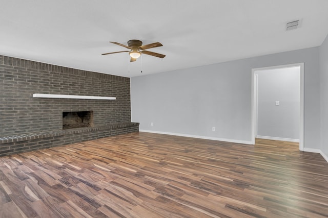 1507 Linda St, Bowie, TX 76230 - unfurnished living room with a ceiling fan, wood finished floors, baseboards, and a brick fireplace