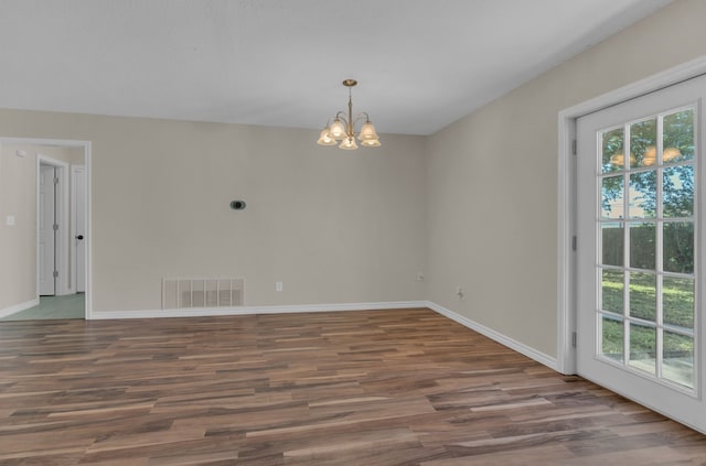 1507 Linda St, Bowie, TX 76230 - empty room with healthy amount of natural light, a chandelier, wood finished floors, and baseboards