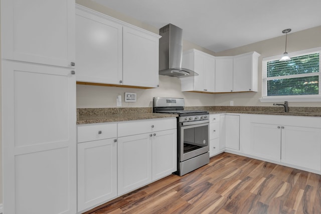1507 Linda St, Bowie, TX 76230 - kitchen featuring stainless steel range with gas stovetop, wall chimney exhaust hood, white cabinets, wood finished floors, and stone counters