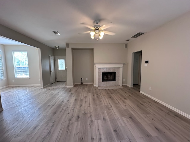 1026 Elm Dr, Providence Village, TX 76227 - unfurnished living room featuring ceiling fan, light wood finished floors, baseboards, and a tile fireplace