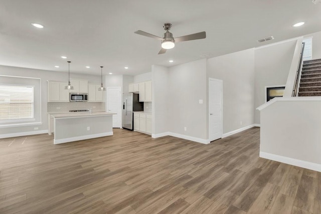 317 Boston Dr, Princeton, TX 74507 - unfurnished living room with a ceiling fan, light wood-style floors, baseboards, recessed lighting, and stairs