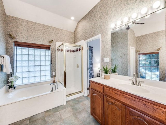 bathroom with plenty of natural light, a stall shower, lofted ceiling, vanity, and a garden tub