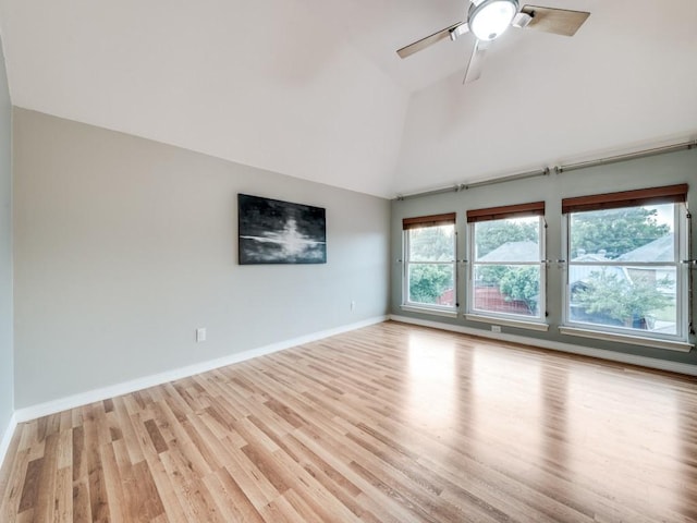 empty room featuring light wood-type flooring, high vaulted ceiling, baseboards, and a ceiling fan