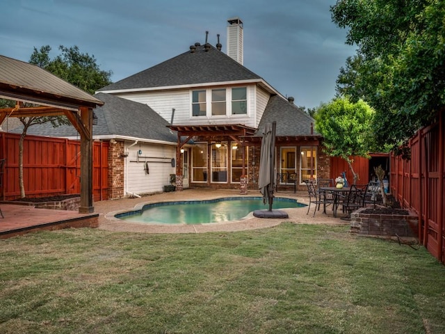 back of property with a pergola, a chimney, roof with shingles, and a patio area