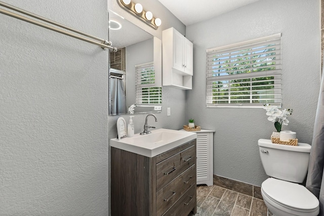 1709 Irving Lee St, Waco, TX 76711 - bathroom with wood finish floors, toilet, vanity, a shower with curtain, and baseboards