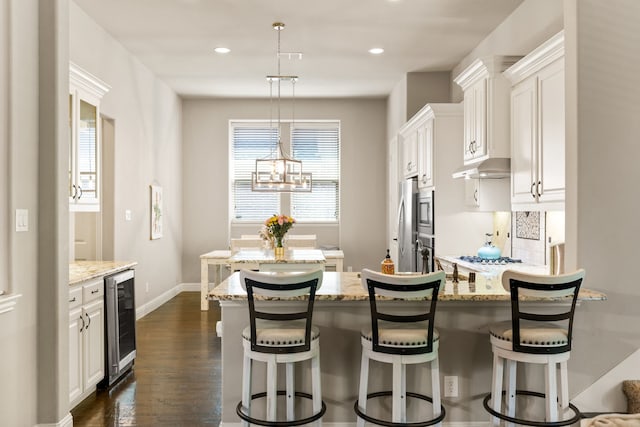 1417 Shenandoah Dr, Mckinney, TX 75071 - kitchen with beverage cooler, light stone counters, a breakfast bar area, dark wood-style flooring, and recessed lighting