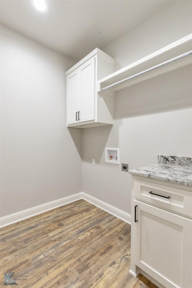 6718 Windmill Grass Ln, Abilene, TX 79606 - laundry area featuring washer hookup, electric dryer hookup, light wood finished floors, baseboards, and cabinet space