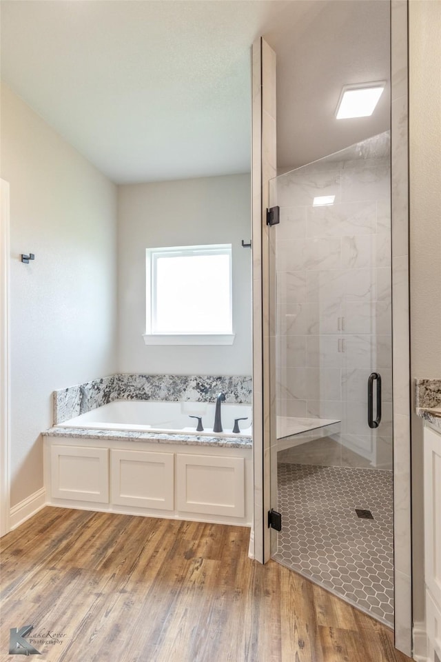 6718 Windmill Grass Ln, Abilene, TX 79606 - bathroom with a stall shower, a bath, and wood finished floors