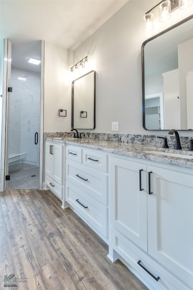 6718 Windmill Grass Ln, Abilene, TX 79606 - bathroom with double vanity, wood finished floors, and a shower stall