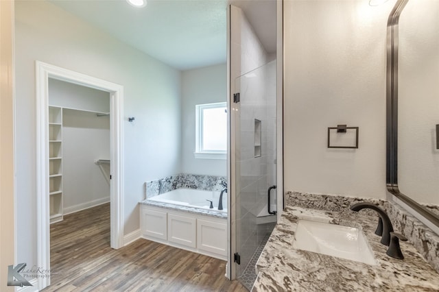 6718 Windmill Grass Ln, Abilene, TX 79606 - bathroom with a stall shower, a garden tub, a walk in closet, wood finished floors, and vanity