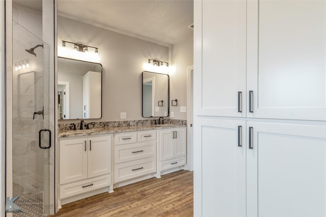 6718 Windmill Grass Ln, Abilene, TX 79606 - full bathroom featuring a shower stall, double vanity, wood finished floors, and a textured ceiling