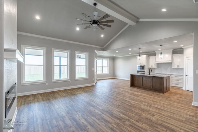 6718 Windmill Grass Ln, Abilene, TX 79606 - kitchen with open floor plan, stainless steel microwave, beam ceiling, an island with sink, and ceiling fan