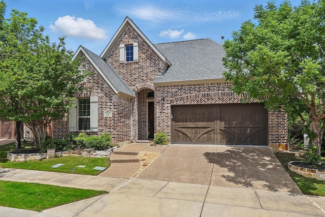 view of front of house featuring brick siding, roof with shingles, an attached garage, and concrete driveway