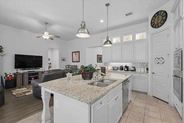 kitchen with appliances with stainless steel finishes, a sink, white cabinets, light tile patterned floors, and a ceiling fan