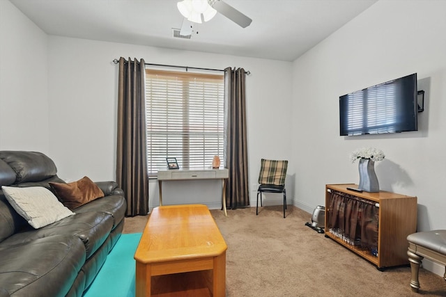 carpeted living area featuring ceiling fan and baseboards