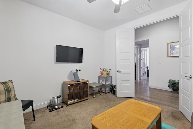 sitting room with a ceiling fan, baseboards, and carpet