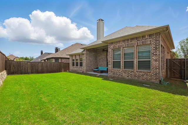 back of property with brick siding, a chimney, and a patio area