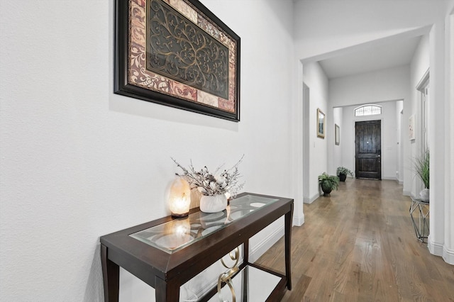 corridor featuring wood finished floors and baseboards