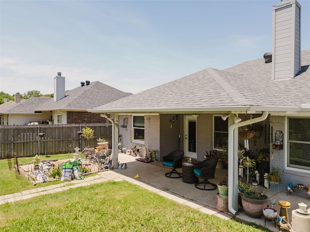 1003 E Burnett St, Ennis, TX 75119 - rear view of house with a chimney, brick siding, a patio area, and roof with shingles