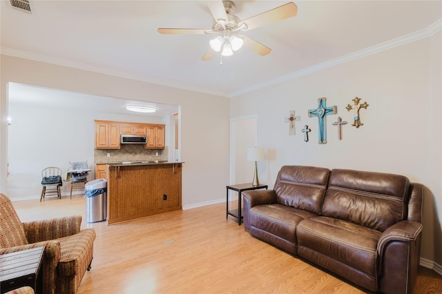 1003 E Burnett St, Ennis, TX 75119 - living area featuring light wood finished floors, ornamental molding, a ceiling fan, and baseboards