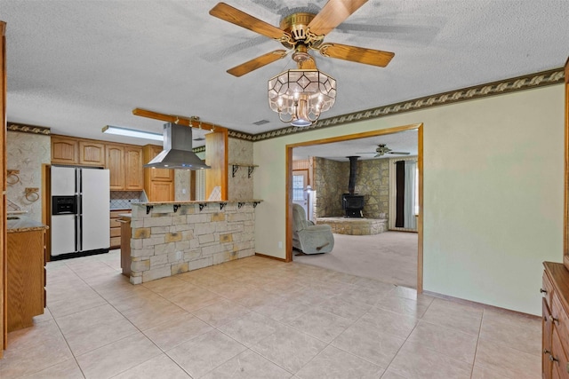 4611 Francis Ct, Granbury, TX 76049 - kitchen featuring white refrigerator with ice dispenser, island exhaust hood, a wood stove, a textured ceiling, and ceiling fan