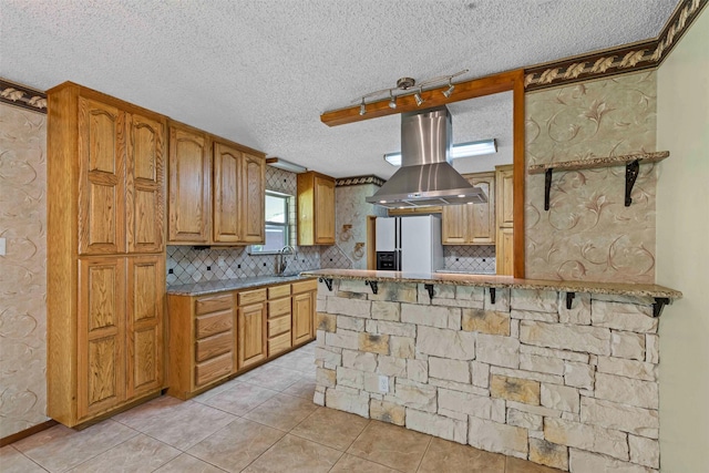 4611 Francis Ct, Granbury, TX 76049 - kitchen with white fridge with ice dispenser, wall chimney exhaust hood, a textured ceiling, backsplash, and light tile patterned floors
