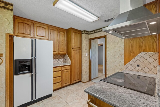 4611 Francis Ct, Granbury, TX 76049 - kitchen with white refrigerator with ice dispenser, wall chimney exhaust hood, black electric stovetop, light tile patterned floors, and brown cabinetry