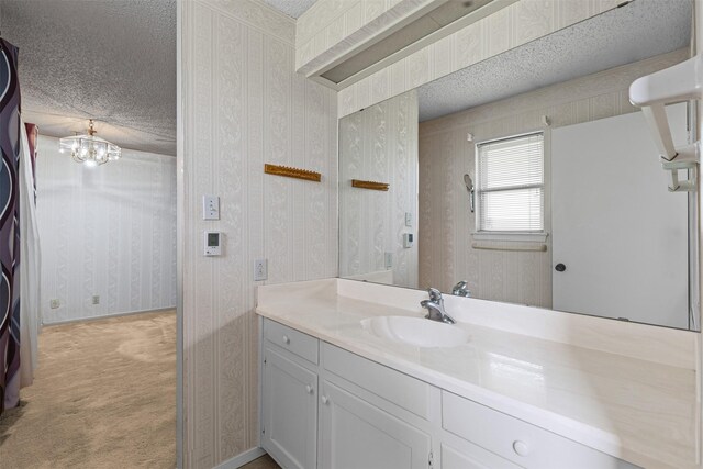 4611 Francis Ct, Granbury, TX 76049 - bathroom with a textured ceiling, vanity, and wallpapered walls