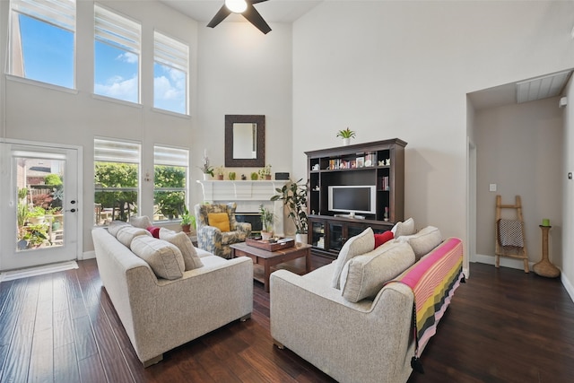14766 Daneway Dr, Frisco, TX 75035 - living area with a towering ceiling, ceiling fan, healthy amount of natural light, a high end fireplace, and dark wood-type flooring