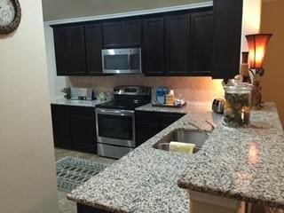 14336 Mariposa Lily Ln, Fort Worth, TX 76052 - kitchen featuring stainless steel appliances, dark cabinets, light stone countertops, and a sink