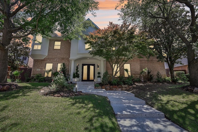 7012 Mills Branch Cir, Plano, TX 75024 - view of front facade with brick siding, a yard, and french doors