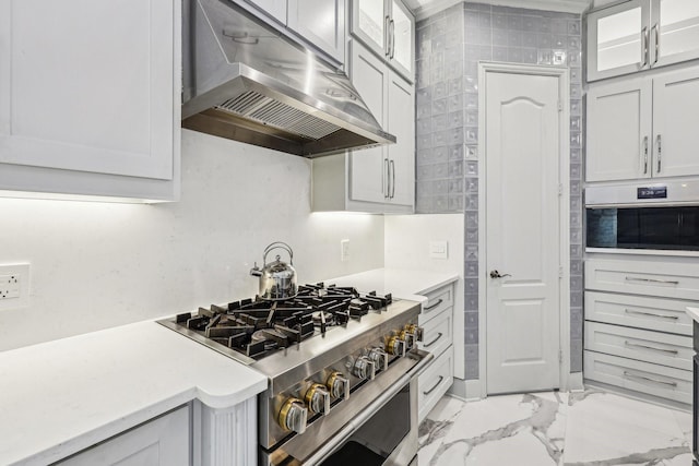 7012 Mills Branch Cir, Plano, TX 75024 - kitchen featuring under cabinet range hood, appliances with stainless steel finishes, light marble finish floors, light countertops, and glass insert cabinets