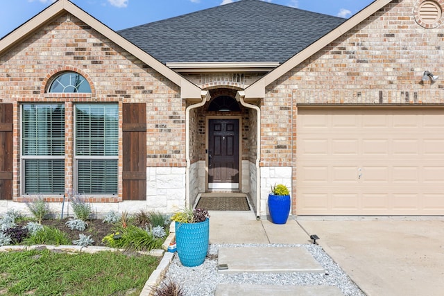 201 E St, Josephine, TX 75173 - doorway to property featuring a shingled roof, brick siding, stone siding, an attached garage, and concrete driveway